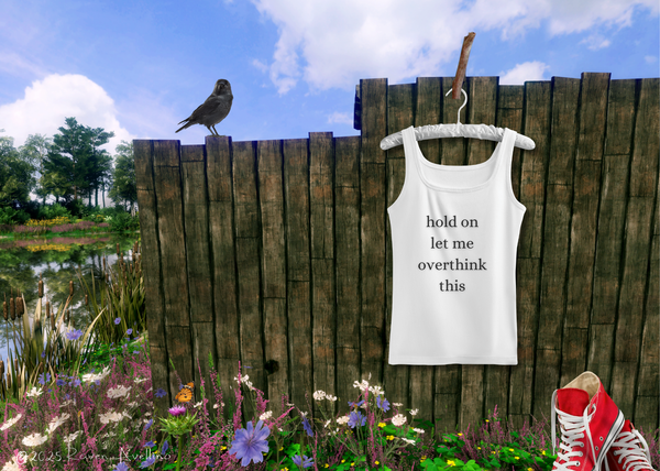 White tank top that says "hold on let me overthink this" hanging on a rustic wooden fence, with a raven perched on the fence, wildflowers below, and red Converse sneakers nearby.